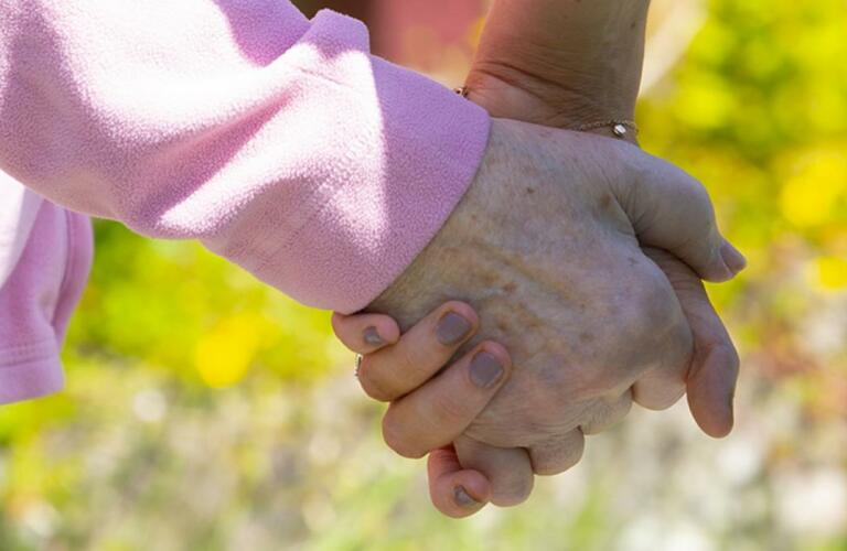 Carer holding hands with resident