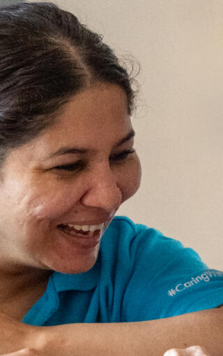 Carer leaning down talking to an elderly resident