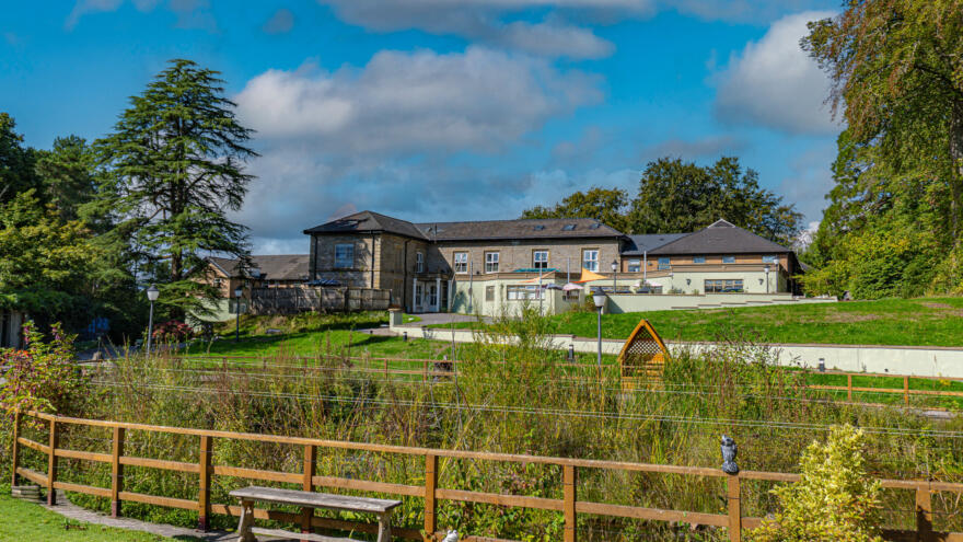 Image shows the front outside of Ysguborwen Care Home with pond